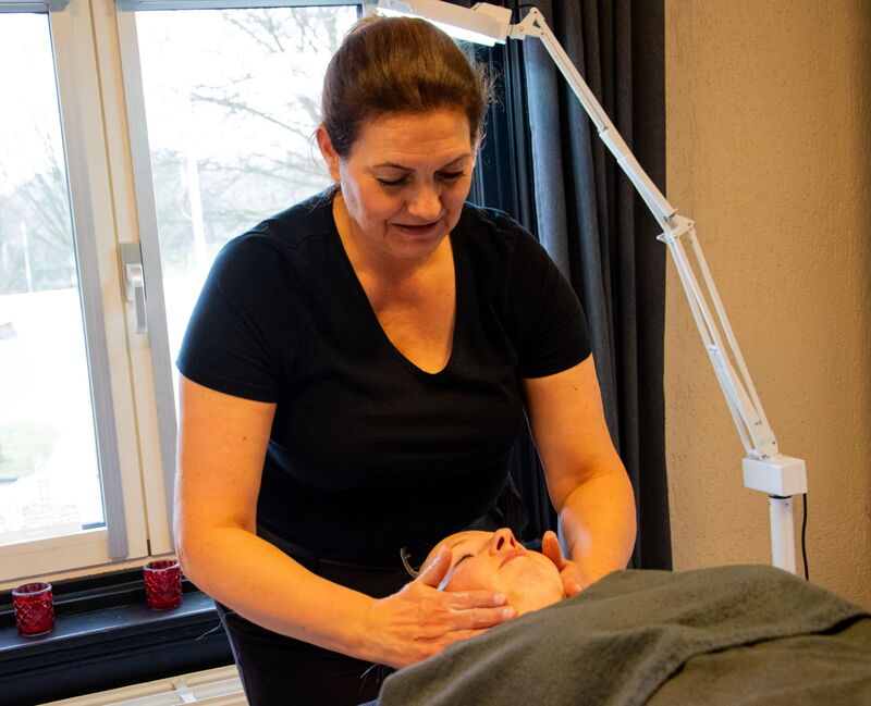 Caroline Voorhoeve masseert het gezicht van een klant tijdens een gezichtsbehandeling